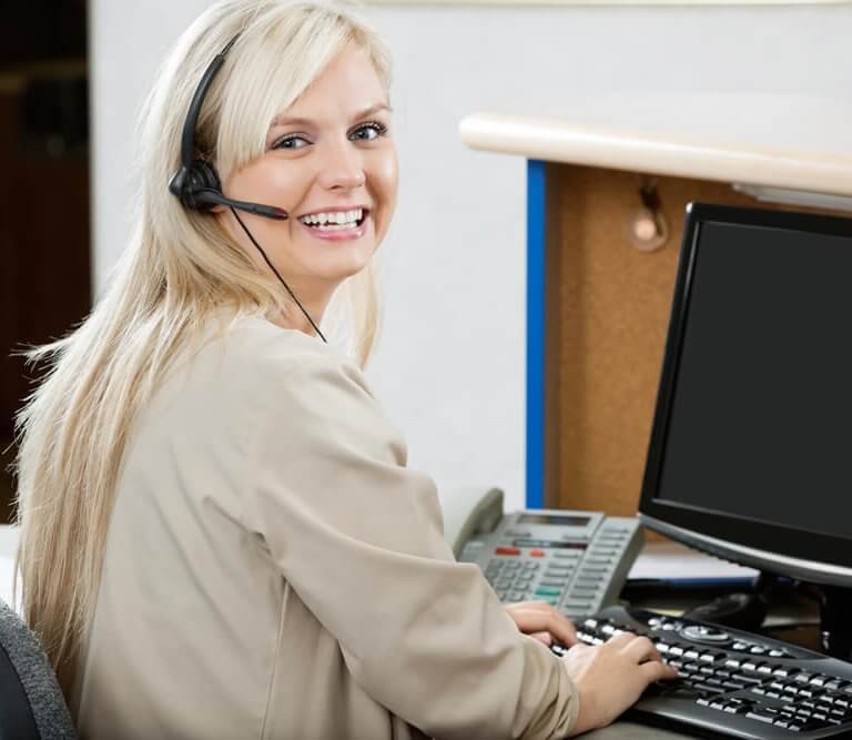 Blonde woman at computer smiling